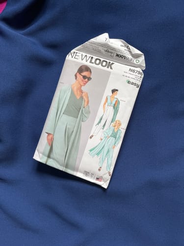Reviewer's navy moss crepe fabric with a sewing pattern for a jacket and trousers lying on top.