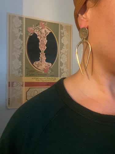 Reviewer wearing the long Uadani brass Earrings, showing how they fall against their neck.