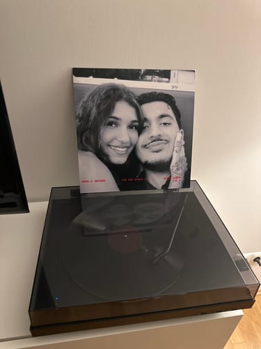Reviewer's Custom Vinyl Record sleeve with a black-and-white photo, displayed behind a record player.