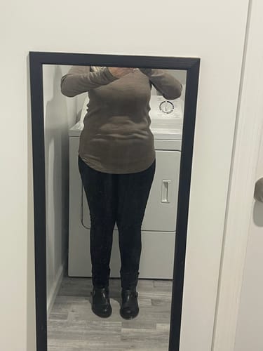 Reviewer shows the fit of the long-sleeved Eva Tunic in taupe, worn with dark pants and boots.