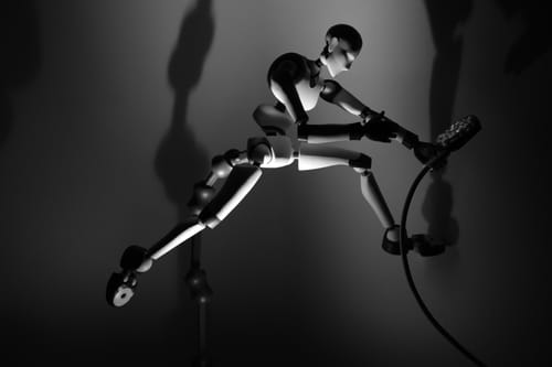 Customer's Stickybones Figure in a dynamic, mid-air pose, supported by the Fly-Rig in a dramatic black and white photo.
