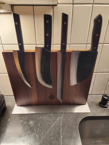 Reviewer's BBQ bundle showing four steel knives displayed on the Walnut Magnetic Board on a kitchen counter.