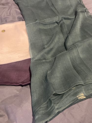 Customer's three crepe fabric pieces in teal, pink, and purple laid out on a bed.