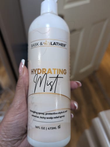 Reviewer holding the large white bottle of XL HYDRATING MIST.