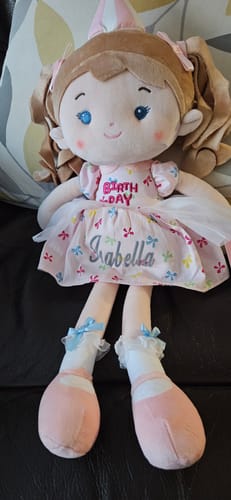 Customer's Personalized Princess Wish doll sitting on a chair, showing the name 'Isabella' embroidered on its pink dress.