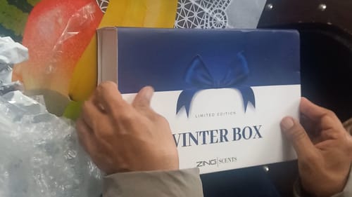 Customer holding a blue and white 'Winter Box' from Zing Scents, mentioned in their review.