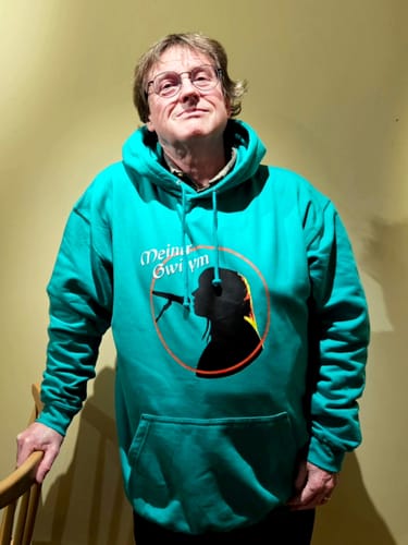 Customer wearing a teal college hoodie with a custom graphic of a singer's silhouette on the front.