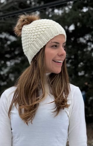 A reviewer smiling while wearing the chunky, cream Kaylee Beanie outdoors.