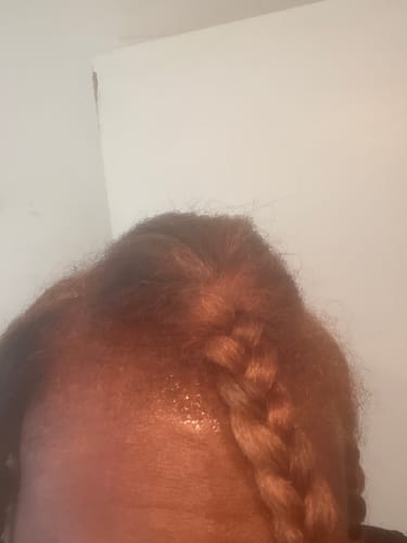 Close-up of a reviewer's hair showing the orange-brown color at the roots after using the Instant Dye Shampoo.