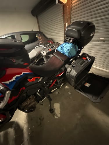 Customer's Wind Rider Seat Cover installed on a motorcycle loaded with touring gear in a garage.