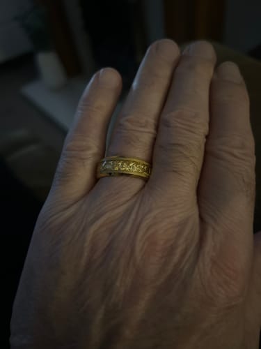 Close-up of a customer wearing the textured gold Aureum ring on their hand.
