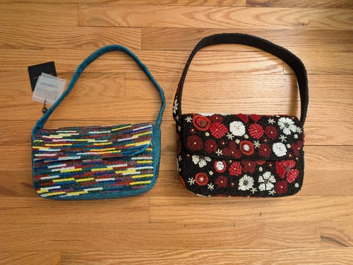 Customer's Scarlet Romance Embellished Shoulder Bag next to a multicolored beaded bag on a wooden floor.