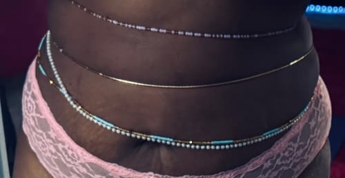 Reviewer's midsection showing the Gold Sparkle Tie On Waist Bead worn with other colorful waist bead strands.