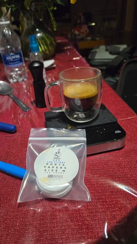 Customer's Size M Espresso Paper Filters in a bag, with a finished glass of espresso on a digital scale.
