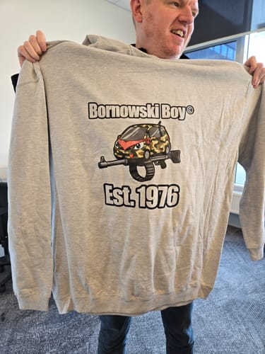 Reviewer holding up their grey Varsity hoodie with a large custom 'Bornowski Boy' graphic.