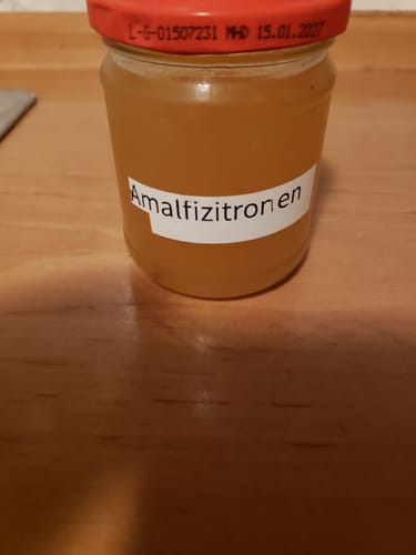 Kunde zeigt ein Glas mit hausgemachtem Gelee, hergestellt aus den Bio-Amalfizitronen.