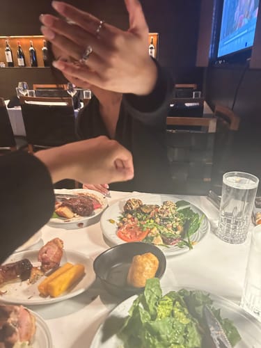 Customer holding up their hand to show the STARGAZERS RING while at a restaurant.