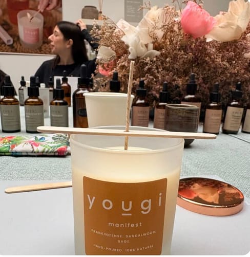 Customer photo from the Yougi Perfume Making Workshop showing a table with essential oils and a branded candle.