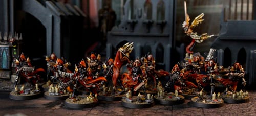 Customer's painted Exemplar Sisters miniatures from the Heavy Fire Packs, shown in a battle formation with red and black armor.