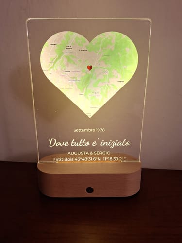 Rezensent zeigt beleuchtete, personalisierte Nachtleuchte mit herzförmiger Karte und Holzsockel.