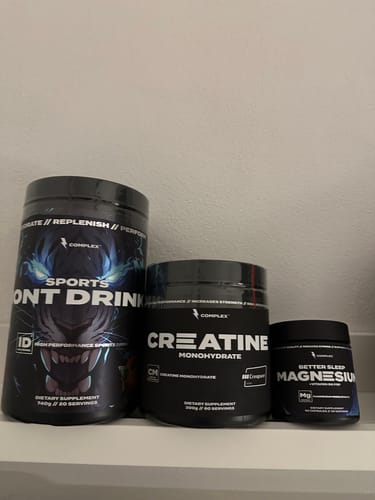 Customer's three black supplement containers from the Ultimate Performance Bundle arranged on a white shelf.