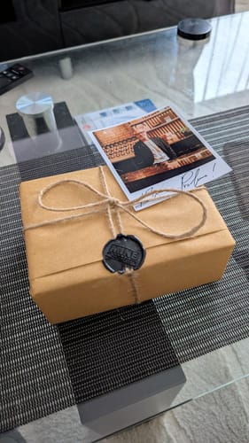 Recensore mostra la confezione del profumo ABSOLUTE SANTAL, accuratamente imballata con spago e ceralacca.