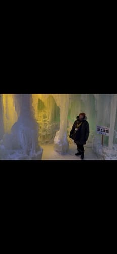 Reviewer wearing the black Frost Petite Duralite® Leggings inside a lit ice structure during a winter festival.