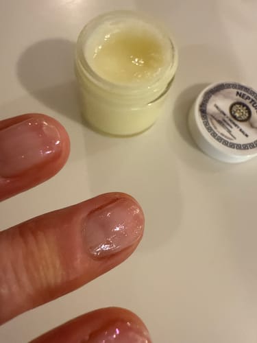 Reviewer's shiny cuticles with an open jar of Grass Fed Tallow & Honey Balm in the background.