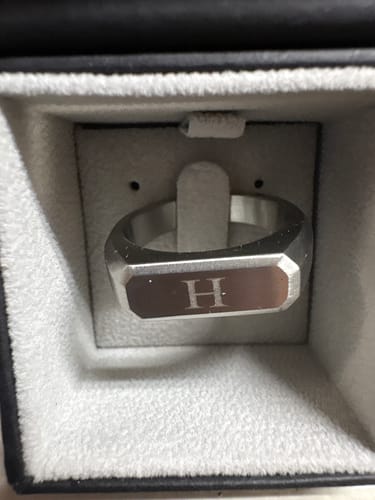 Customer's engraved Rectangle Matte Signet Ring with the initial 'H' shown inside a padded ring box.