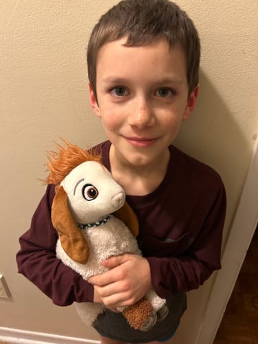 A smiling customer holding the soft Tali Plushie.