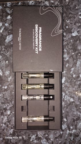 Reviewer's open Fragrance Discovery Kit on a counter, showing four of the five sample vials inside the box.