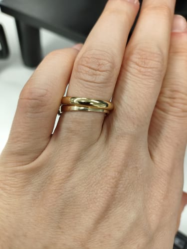 Customer showing their gold-tone 3mm Dome Wedding Band stacked with another ring on their finger.