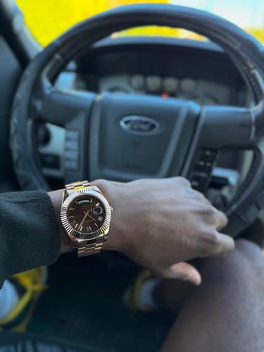Customer showing their rose-gold Lucky Fours® Santos watch on their wrist while in a car.