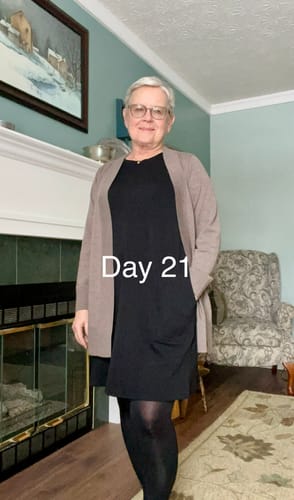 Reviewer wearing the Simply Taupe Macie Sweater open over a black knee-length dress indoors.