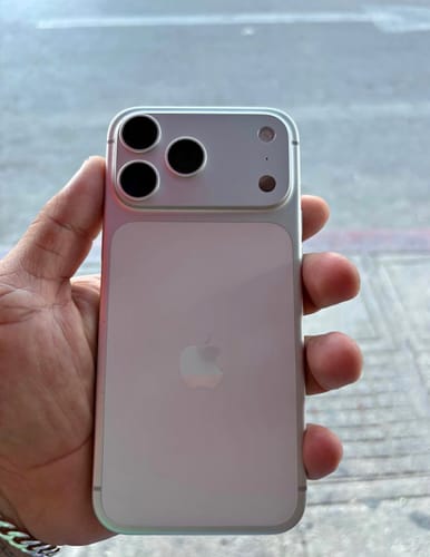 Cliente sosteniendo en la mano su IPHONE 17 PRO MAX plateado, mostrando la parte trasera y las cámaras.