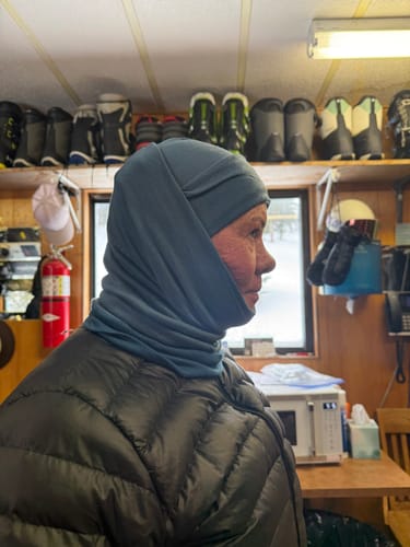 Customer wearing a custom-made steel blue head and neck covering indoors.