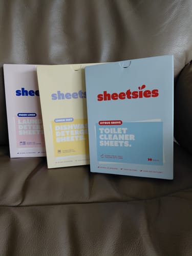 Reviewer's Sheetsies Bundle showing the slim cardboard boxes for laundry, dishwasher, and toilet cleaner sheets.
