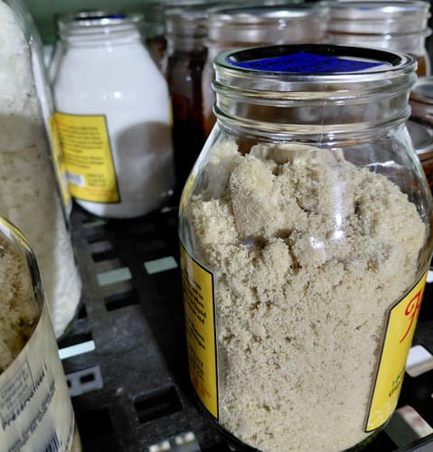 Close-up of a reviewer's sealed wide-mouth jar of food on a stocked pantry shelf.