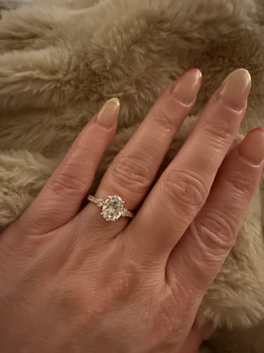 Customer's hand wearing the Luna - Rose Gold ring, showing the sparkling oval stone and pave band.