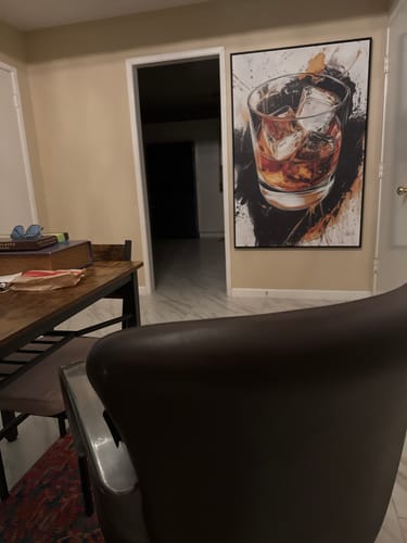 Customer's Whiskey Reflections on Ice canvas print hung on a light-colored wall in a home.