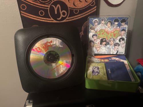 Customer's Lezhin Season's Greetings 2026 set. The CD is in a portable player next to the open case showing photocards and other items.