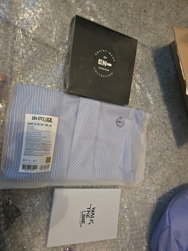 Customer's unboxed K-POP Random Box showing an ENHYPEN shirt and tie set and a Sunghoon Artist-Made Collection box.