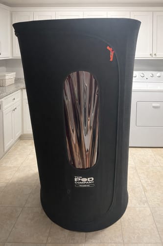 Customer's black Sauna Pod 2.0 fully assembled on a tiled floor inside a home.