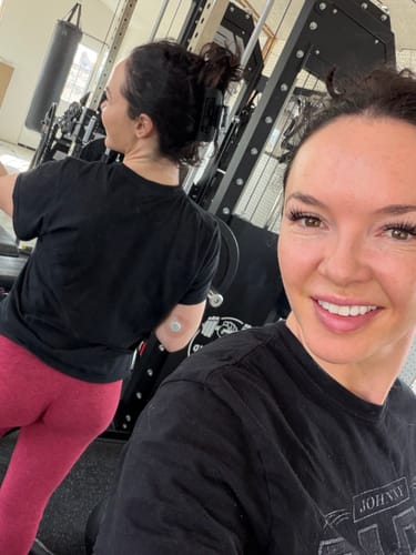 Reviewer at the gym with their dark hair held up in a bun by the cloud clip.