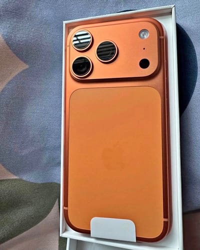 Reseñador muestra el IPHONE 17 PRO MAX de color naranja en su caja.