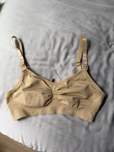 Customer's nude Lovemère Seamless Nursing Bra laid flat on a gray sheet, showing the nursing clasps.