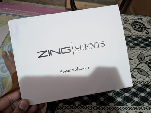 Reviewer holding the white 'Zing Scents' box for the OUD Supreme BUNDLE.