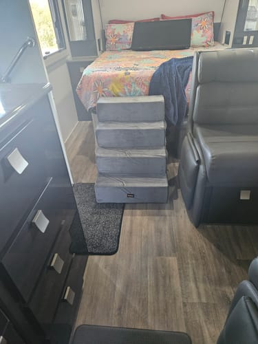 Customer's 5-step grey Pet Foam Stairs placed by a high bed inside a caravan.