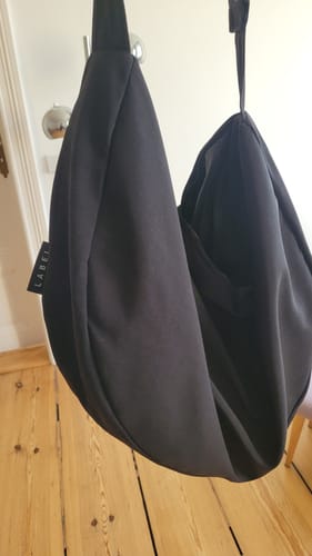 Reviewer's SIV bag in black, hanging indoors to show its soft, slouchy shape.
