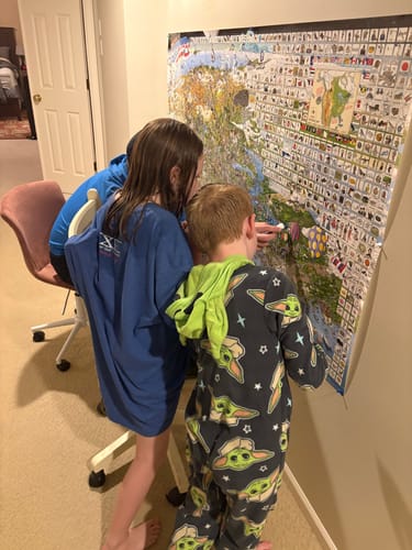 Reviewer's family gathered around the large World's Greatest Search & Discover poster, looking for hidden items.